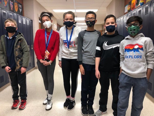  six students stand in the middle of a hallway at school